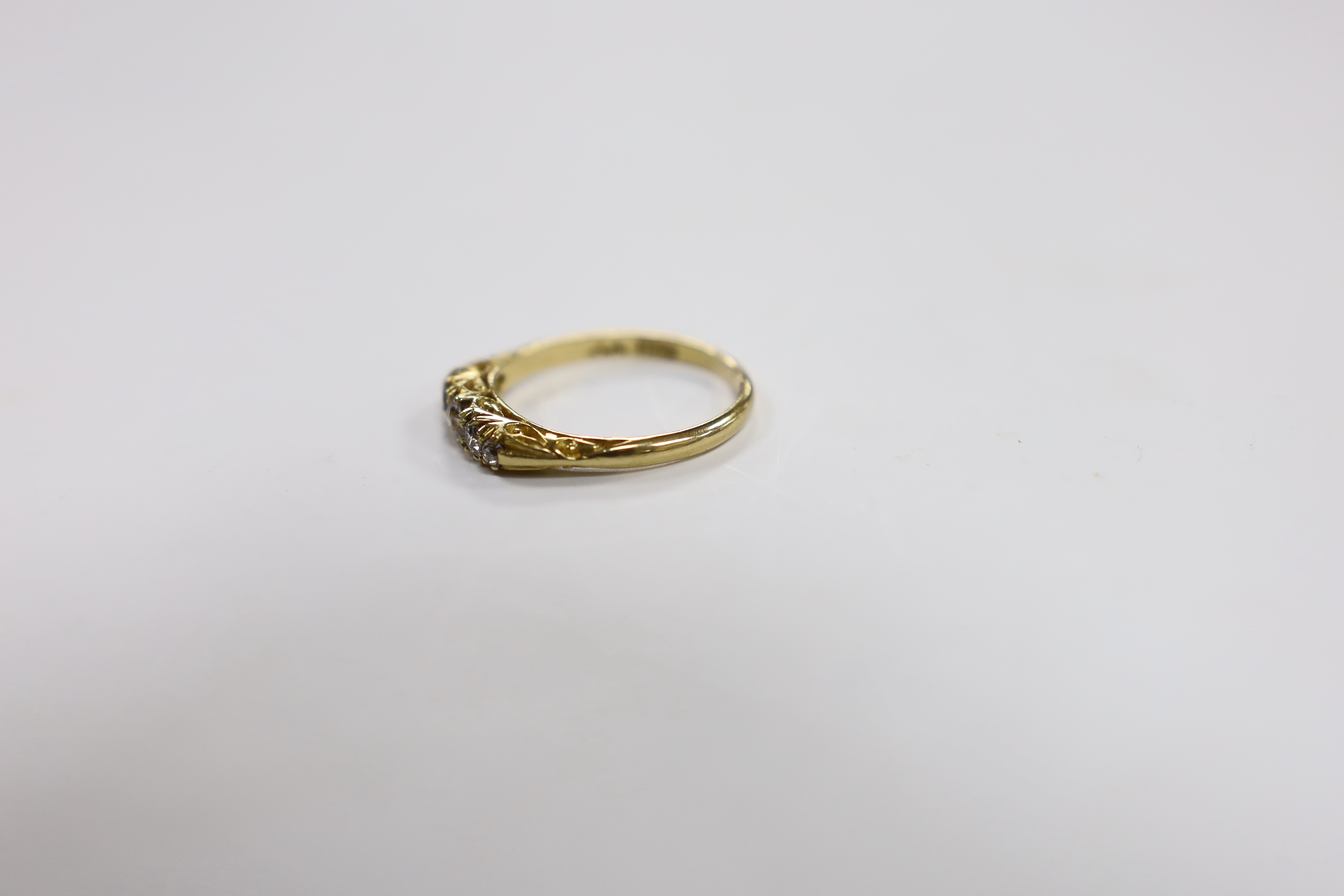 An 18ct and graduated five stone diamond set half hoop ring, size P/Q, gross weight 3.7 grams.